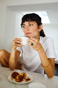 Model wearing Donatella Ring with green statement stone and gold setting