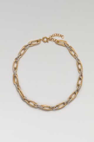 Allegra necklace, gold and rhodium plated, lying in a circle with its spring-ring clasp and extender