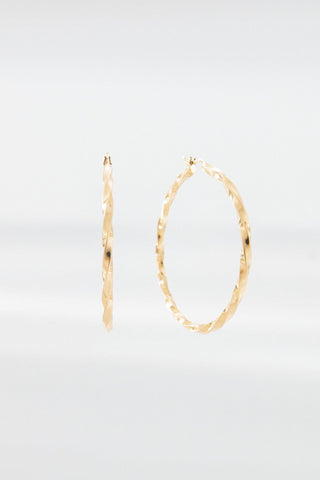 Carmela gold hoop earrings with twisted design shown on a white background
