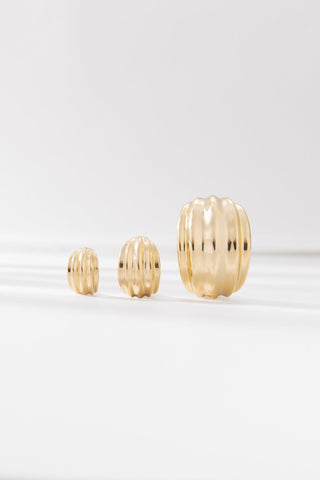 Rafaella gold mini hoop earrings shown in multiple sizes, highlighting sculptural ribbed gold design.